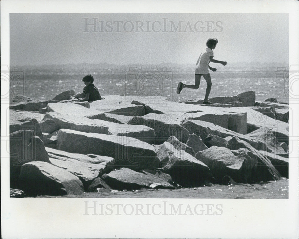 1983 Press Photo Brothers Paul And Adam Landry Playing Around Rocks Yacht Basin - Historic Images