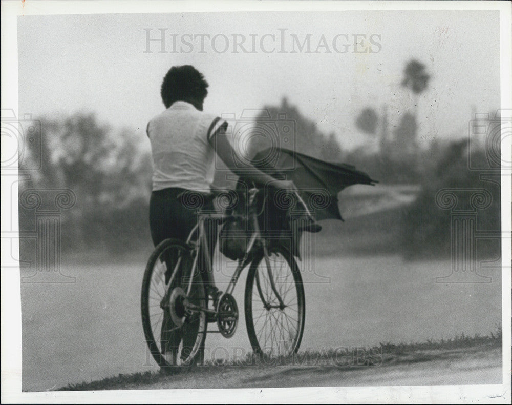 1984 Press Photo Bicyclist Walks Along Belleair Causeway-Storm Broke Umbrella - Historic Images