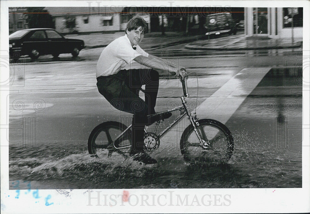 1987 Press Photo Man Pedals Home In Rain on 4th Street In Pinella County - Historic Images