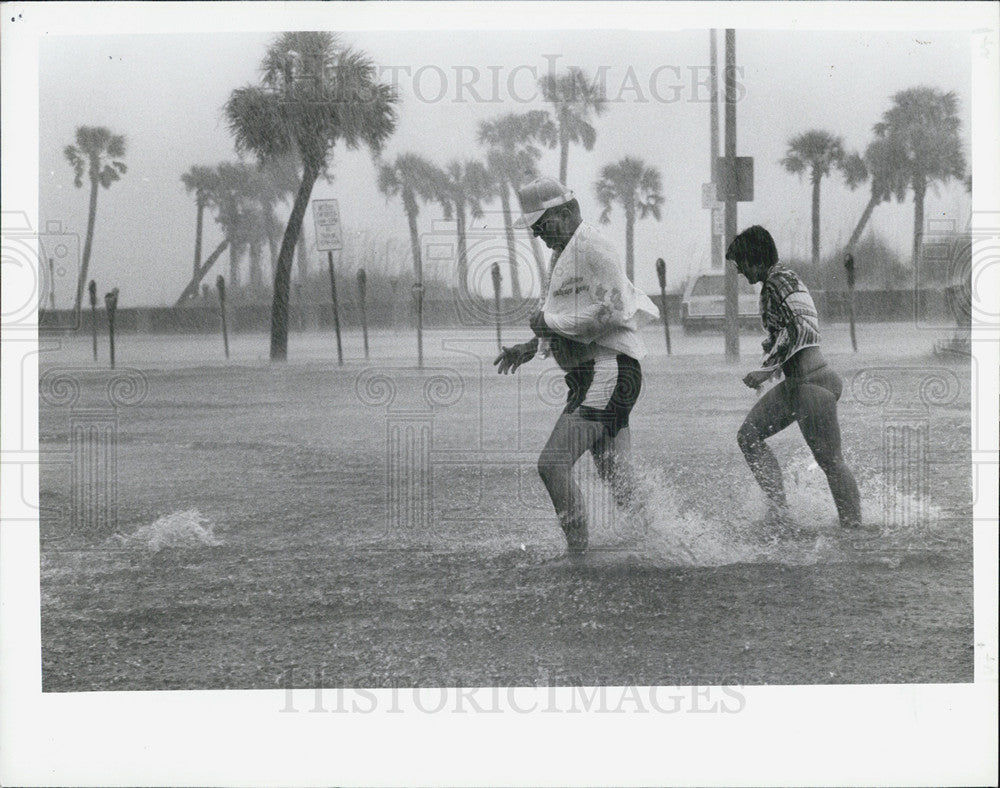 1987 Press Photo Gulf Blvd Rains On Beach Goers As They Run To Hotel - Historic Images