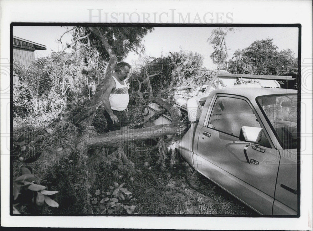 1986 Press Photo J.E. Elam Surveys Pickup Damaged Top Tree Wind Storm Gulfport - Historic Images