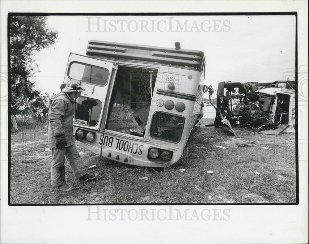 1985 Press Photo Firefighter looks into an overturned Manatee County School Bus - Historic Images