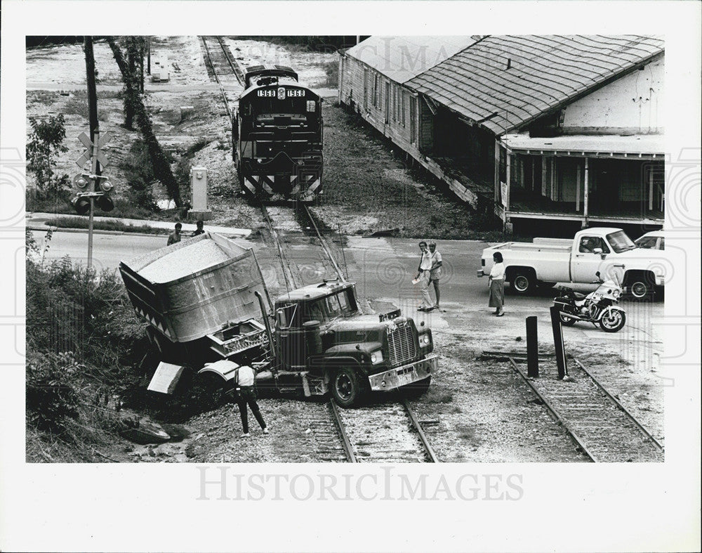 1987 Press Photo Rock truck straddles tracks after colliding w/ train engine - Historic Images