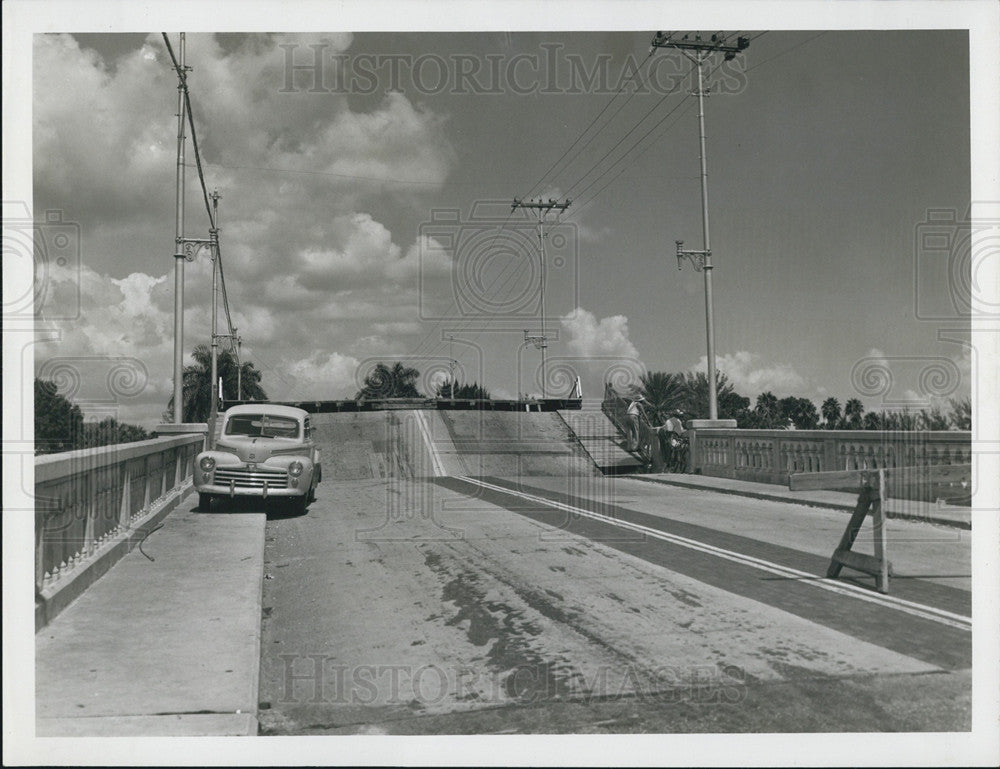 Press Photo Car on curb of bridge - Historic Images