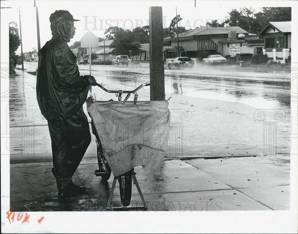 1987 Press Photo Mail carrier Willie James takes shelter from rain - Historic Images