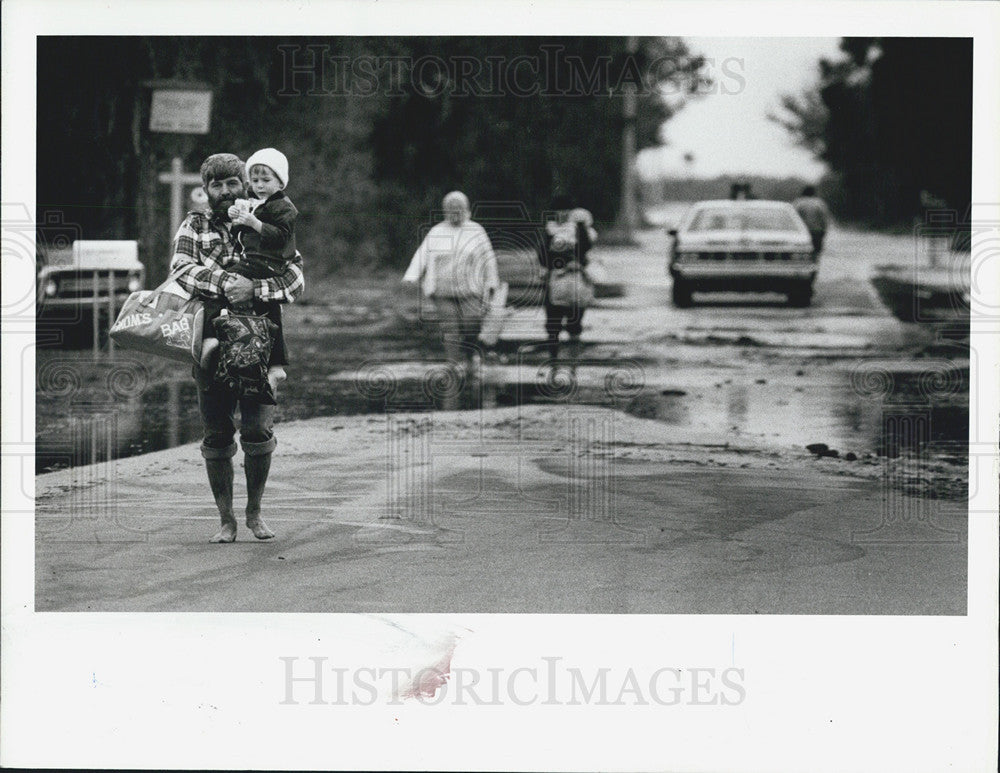 1983 Press Photo Visitor John Brinson Carrying Son During Evacuation Florida - Historic Images