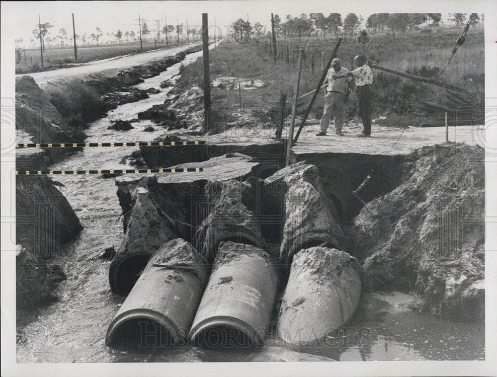 1959 Press Photo Merlyn Almack Points Deep Chasm Car Sank Into Road Gave Way - Historic Images