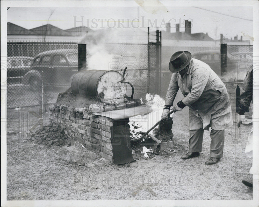 1952 Press Photo Food Inspector Keeps Fire Going Under Water Tank - Historic Images