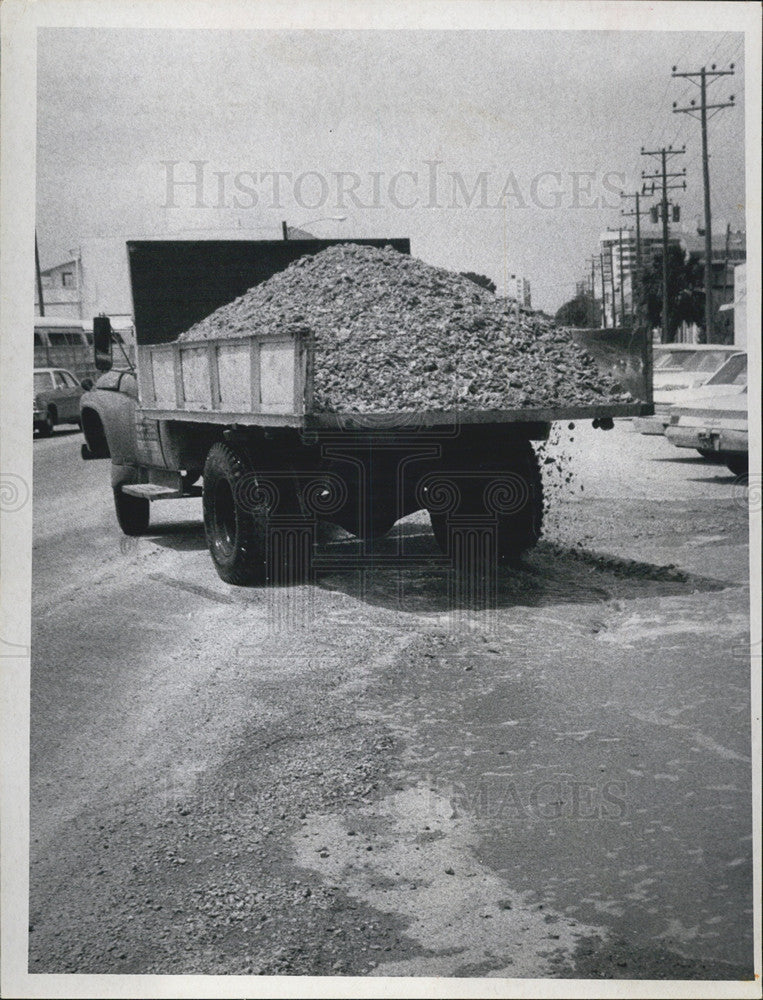 1970 Press Photo Truck Carrying Gravel And Shells Spilling On Road - Historic Images