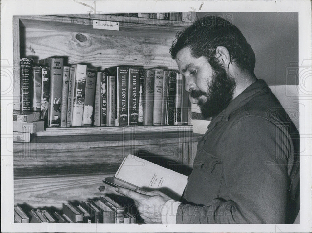 1958 Press Photo A Naval officer brushing up on his reading at the library - Historic Images