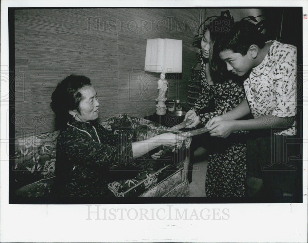 1992 Press Photo Chinese Grandmother Gives Children Lucky Money On New Years - Historic Images