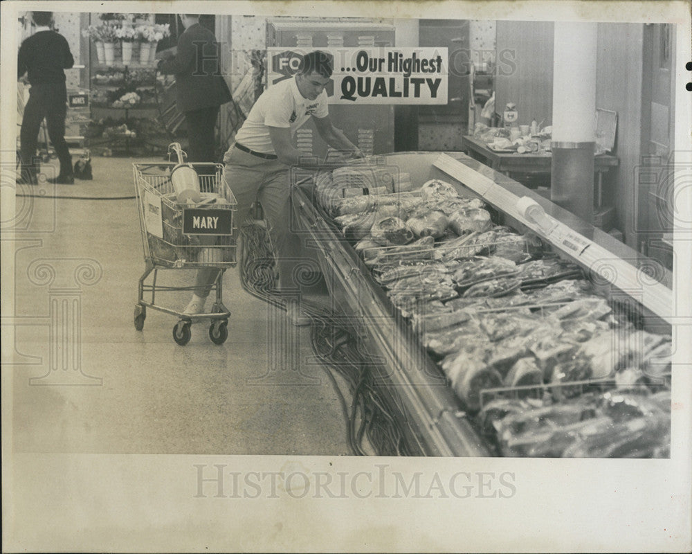 1967 Press Photo Runner Jim Metcalfe hurries to fill up the shopping cart - Historic Images