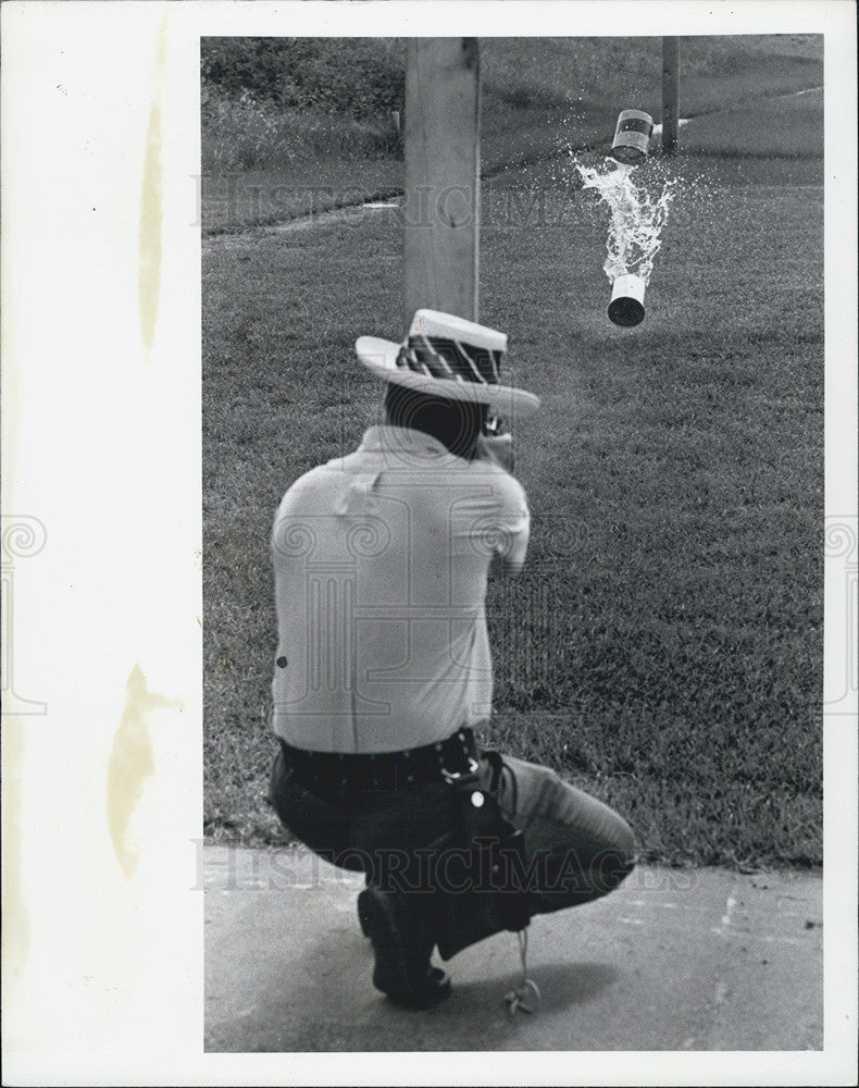 1975 Press Photo of Ron Getman demonstrates shocking power of 22 cal pistol. - Historic Images