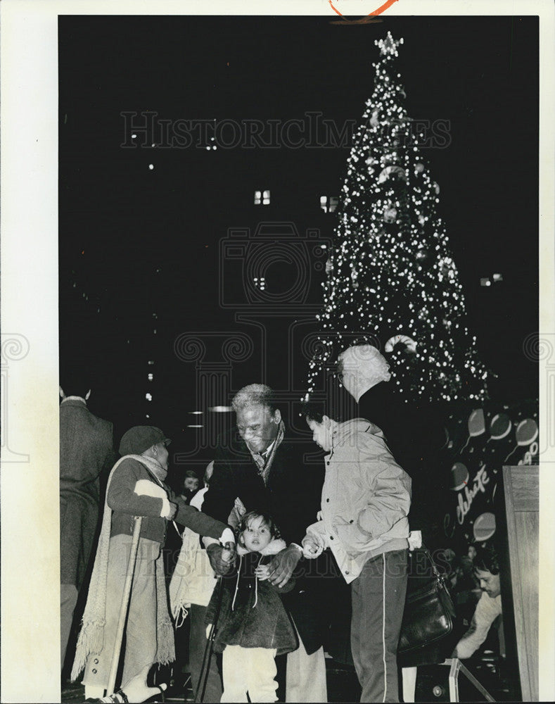 1984 Press Photo Mayor Washington helps children light the city Christmas tree. - Historic Images