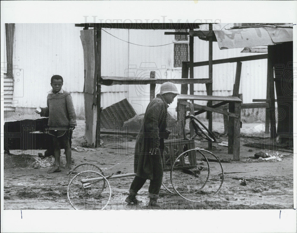 1990 Press Photo A South African boy uses spare parts to build a bike - Historic Images