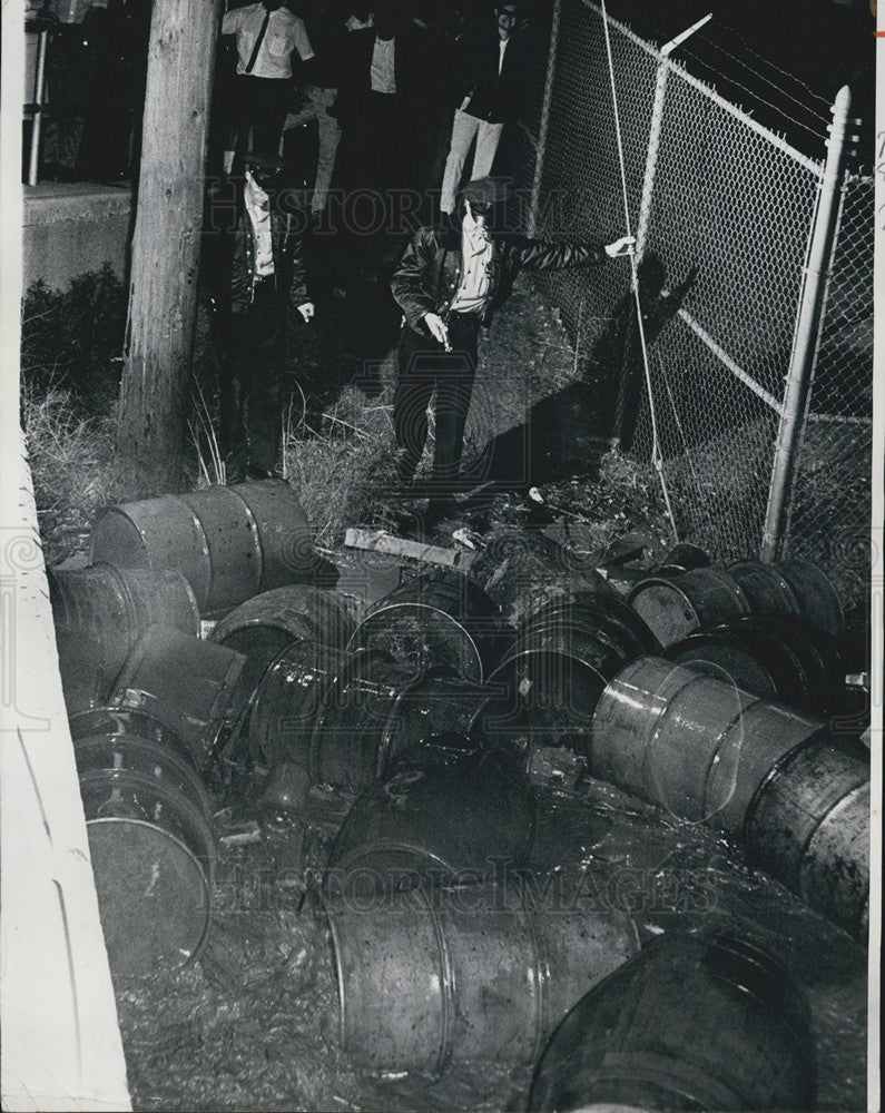 1965 Press Photo Policemen Gene Gray &amp; Fred Stevenson check oil drums swept by floods - Historic Images