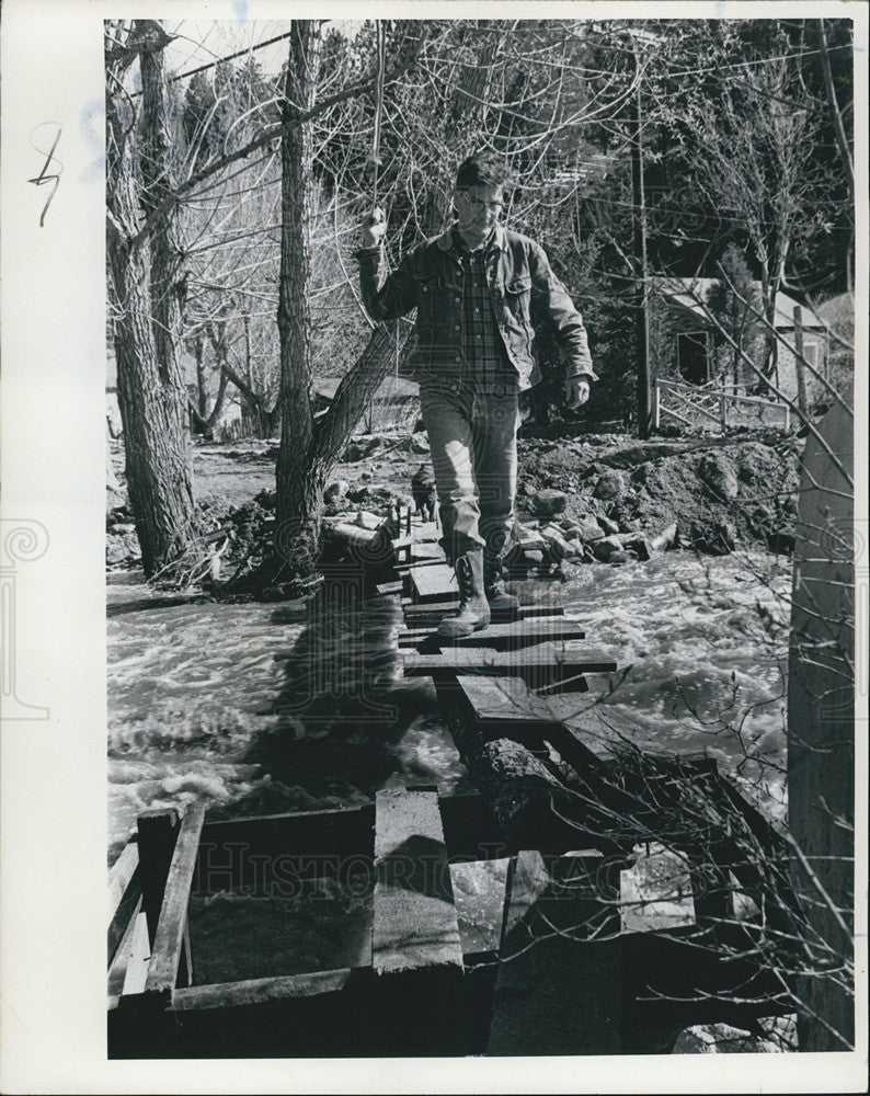 1969 Press Photo Man Walks Across Man Made Bridge on Jim Creek During Flooding - Historic Images