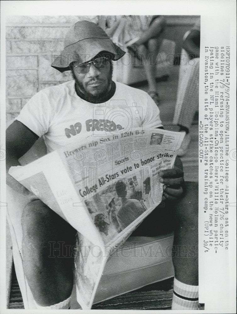 1974 Press Photo Bears Willie Holman Reads Paper During Dolphin Charity Game - Historic Images