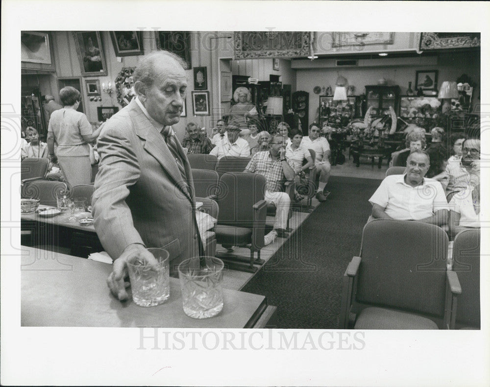 1985 Press Photo Brown Art Gallery Harold Flutie Auctioning off glassware - Historic Images