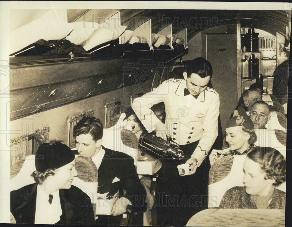 1964 Press Photo Being served coffee aboard a flight - Historic Images