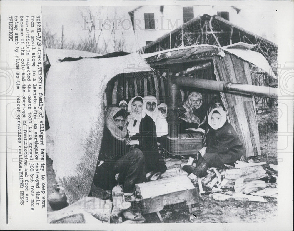 Press Photo A family of villagers try to keep warm after earthquake. - Historic Images