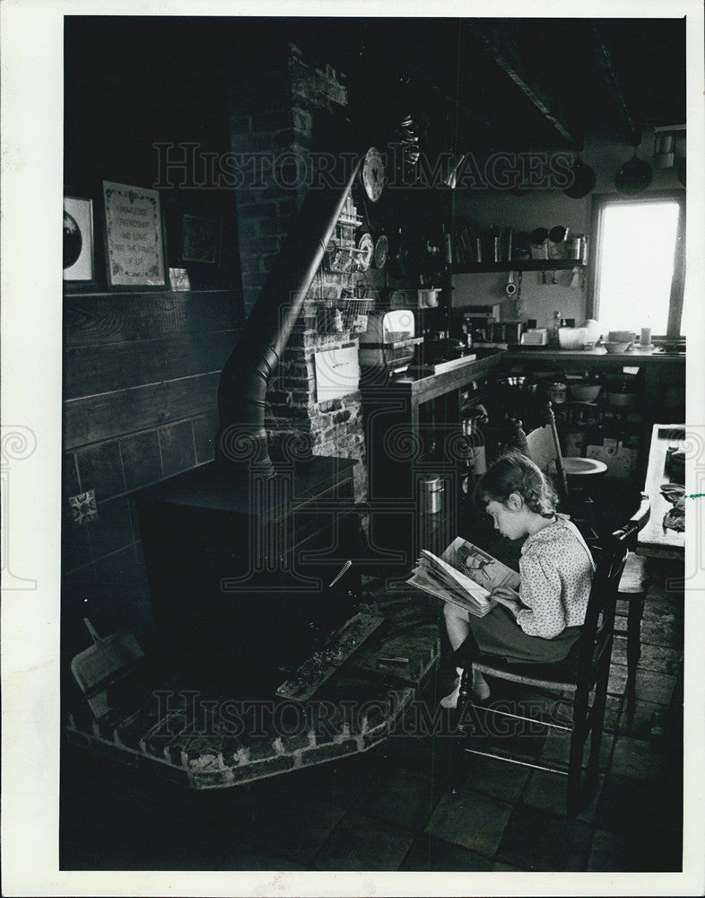 1982 Press Photo Nancy Eberle&#39;s daughter Kate reads a book in the kitchen - Historic Images