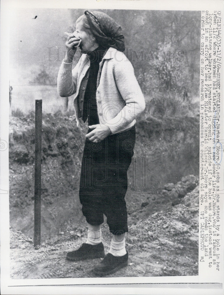 1964 Press Photo Dr. Barbara Moore stands by a hole in her Garden. - Historic Images