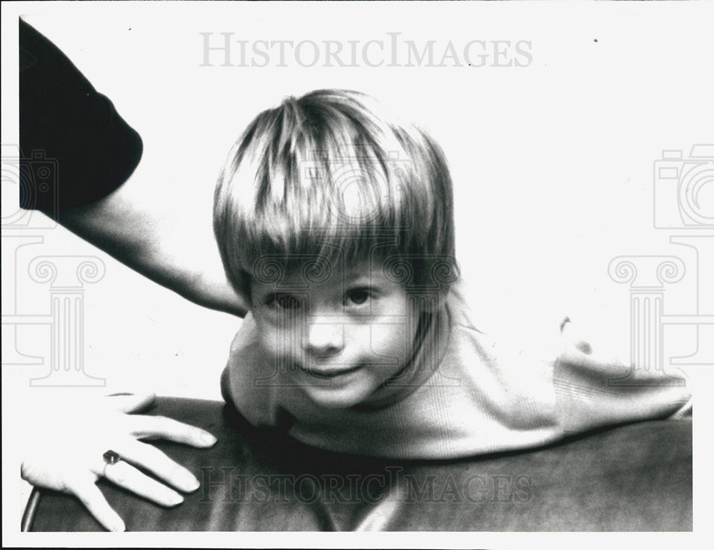 Press Photo A Woman Holds Onto A Boy As He Climbs On Furniture - Historic Images