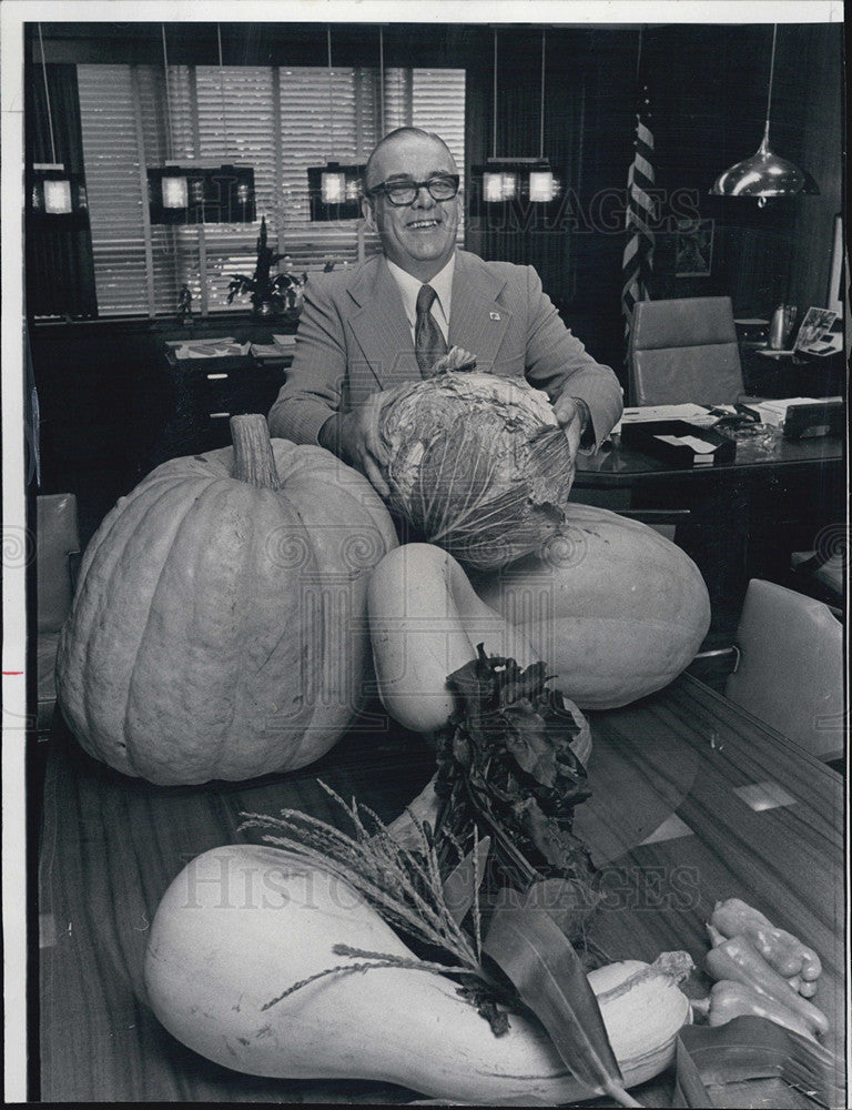 1975 Press Photo James Moore pose with giant vegetables he grew in his garden. - Historic Images