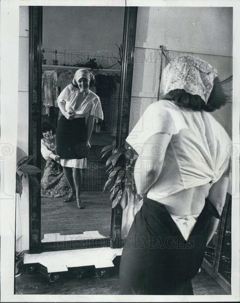 1977 Press Photo Judy Moore at Mrs.Peel&#39;s Boutique,trying to help worn the shirt - Historic Images