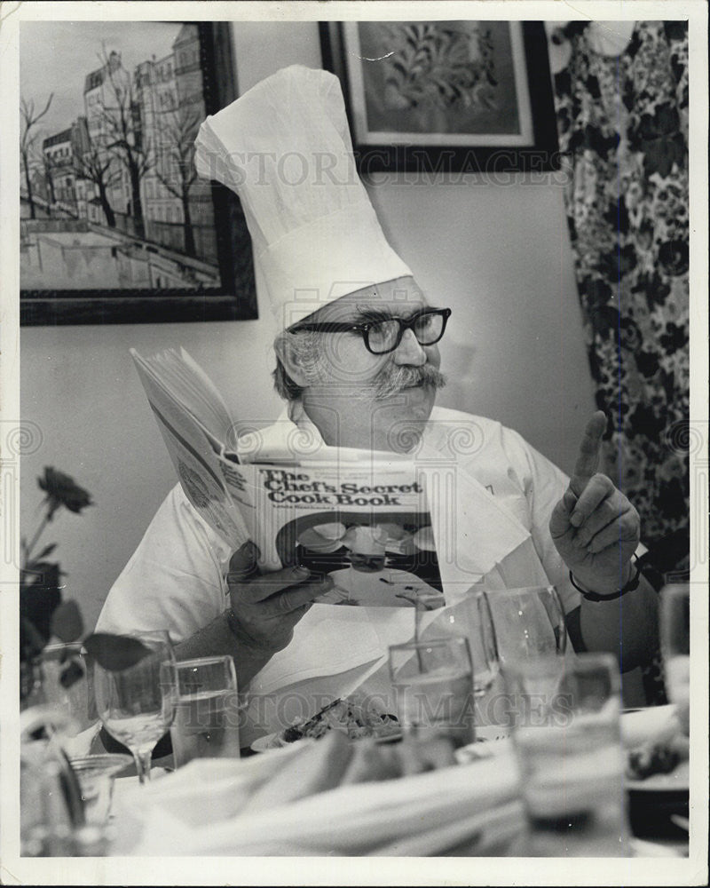 1977 Press Photo Louis Szathmarv explains point in cook book - Historic Images