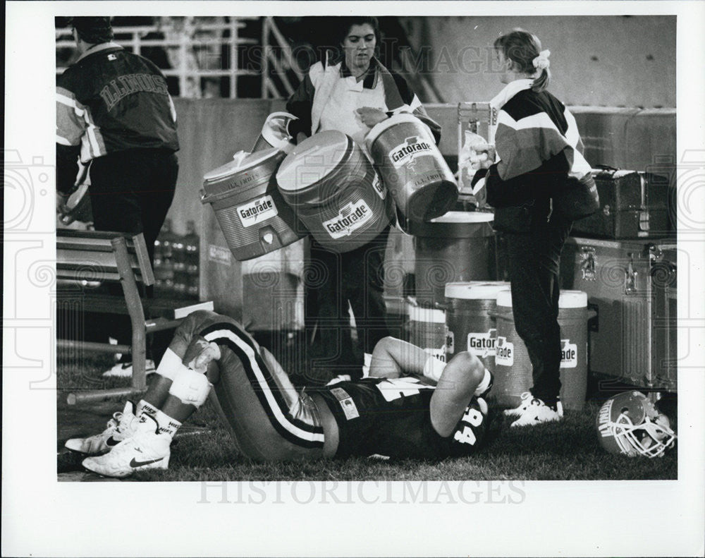 Press Photo Illinois Football Player On Ground Watergirls With Gatorade Jugs - Historic Images