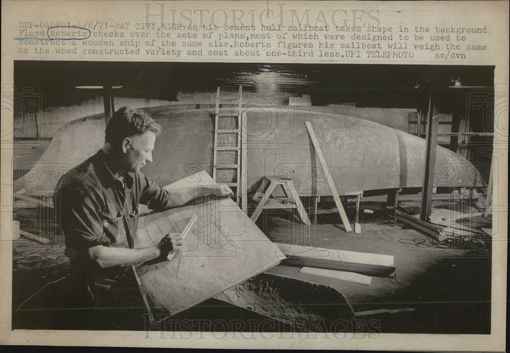 1971 Press Photo Floyd Roberts checks over plans of his cement hull sailboat - Historic Images