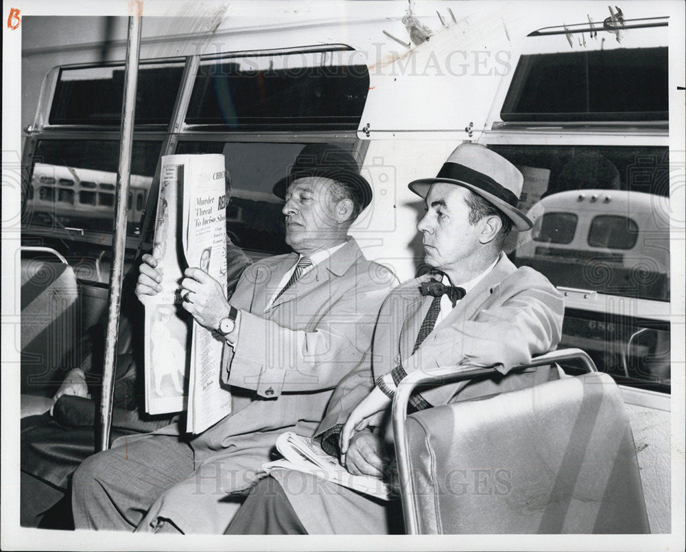 1961 Press Photo Two men holds a pare and fold Lengthwise riding on a Bus. - Historic Images