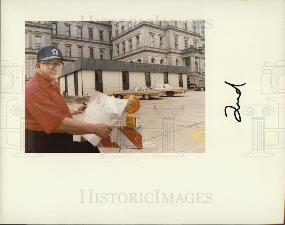 1983 Press Photo Joseph Forbes Pol. Looks at Papers - Historic Images