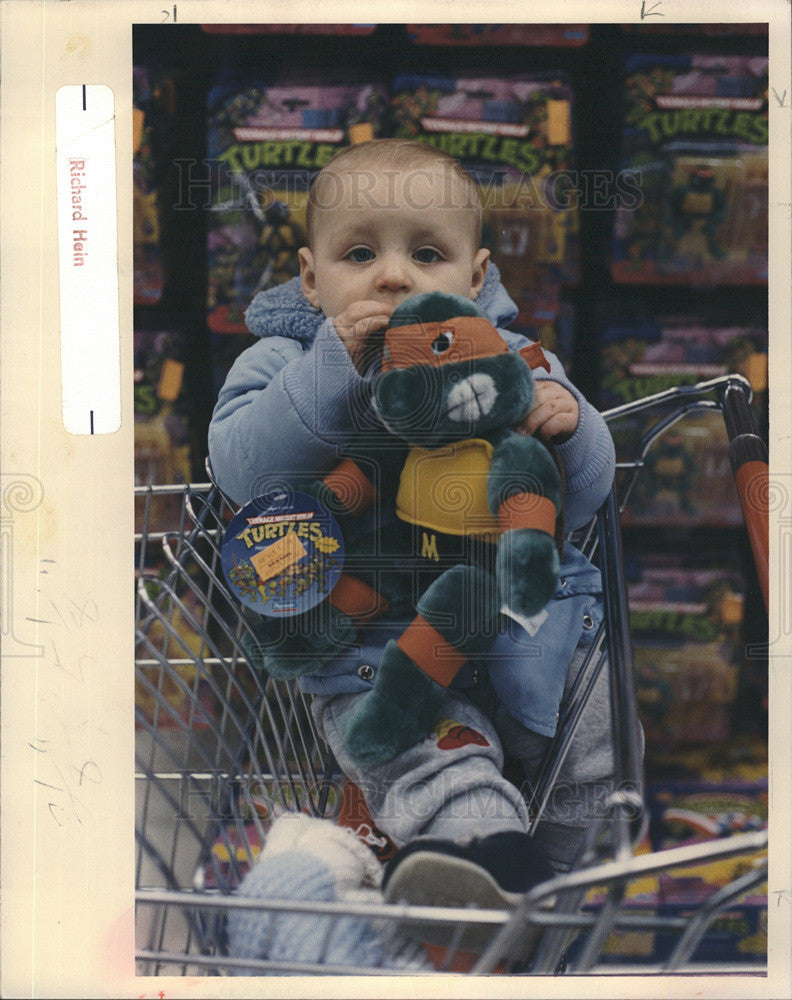 1988 Press Photo Baby snuggles a stuffed Teenage Mutant Ninja. - Historic Images