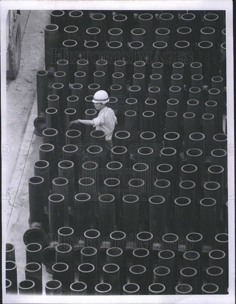 1965 Press Photo Steel yard in Tokyo,worker takes inventory of steel pipes - Historic Images