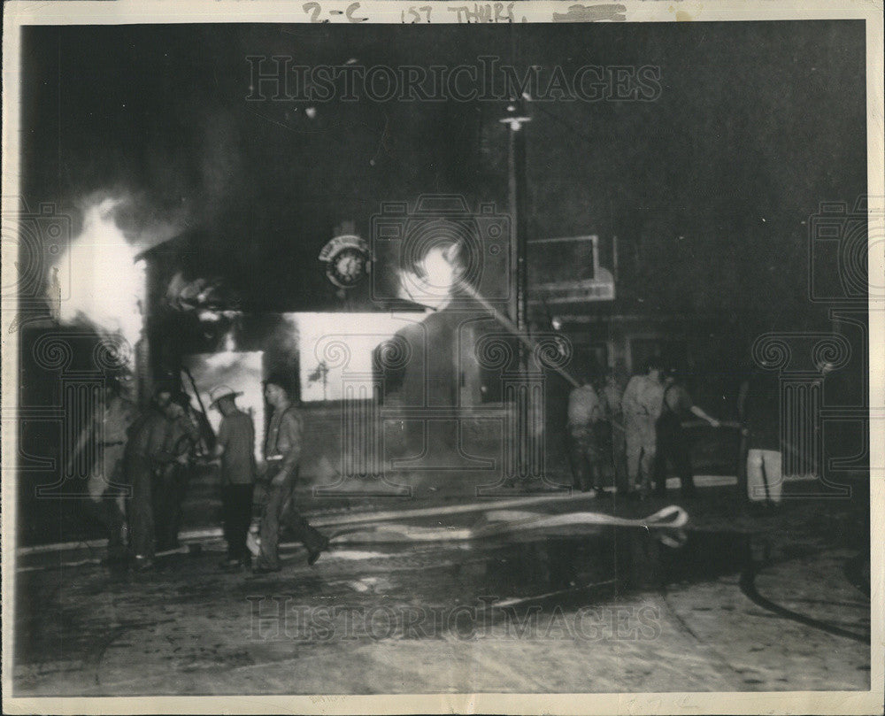 1943 Press Photo Firefighter pour water on burning radio shop. - Historic Images