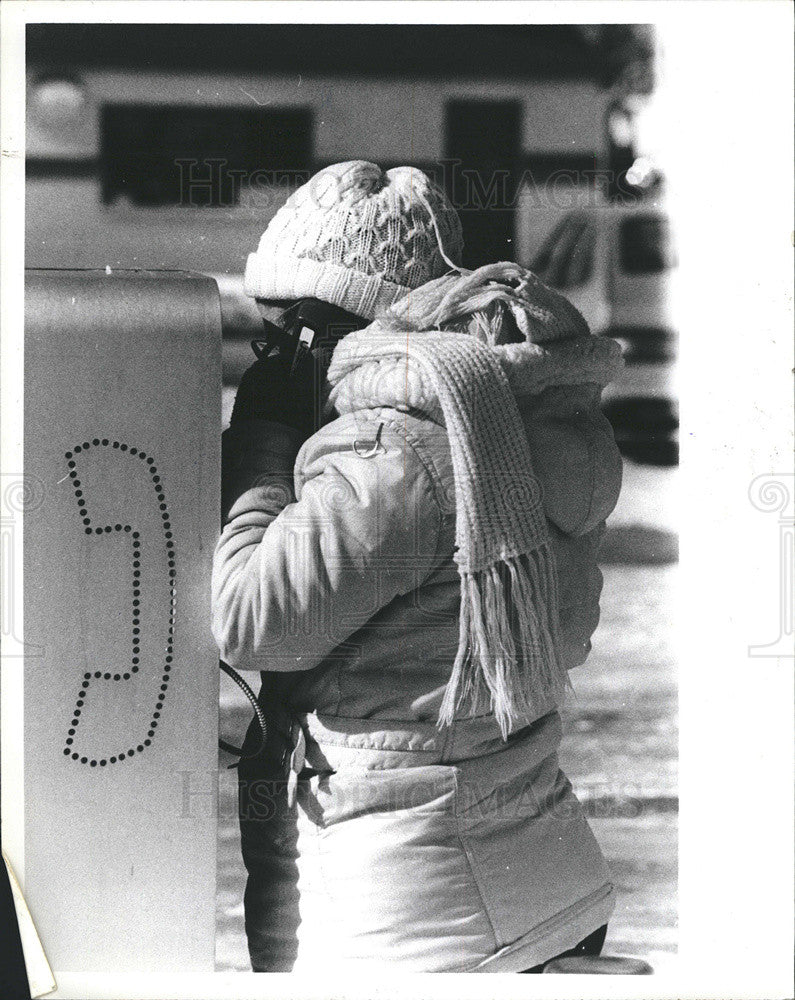 1981 Press Photo Woman on public phone in the winter cold - Historic Images