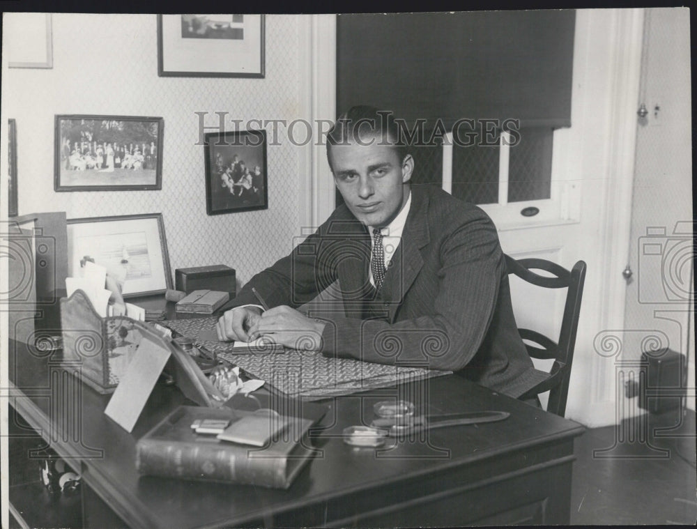 Press Photo Young businessman sitting at desk - Historic Images