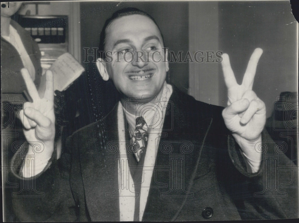 1944 Press Photo Harry Zarief holds up fingers to signify birth of quadruplets - Historic Images