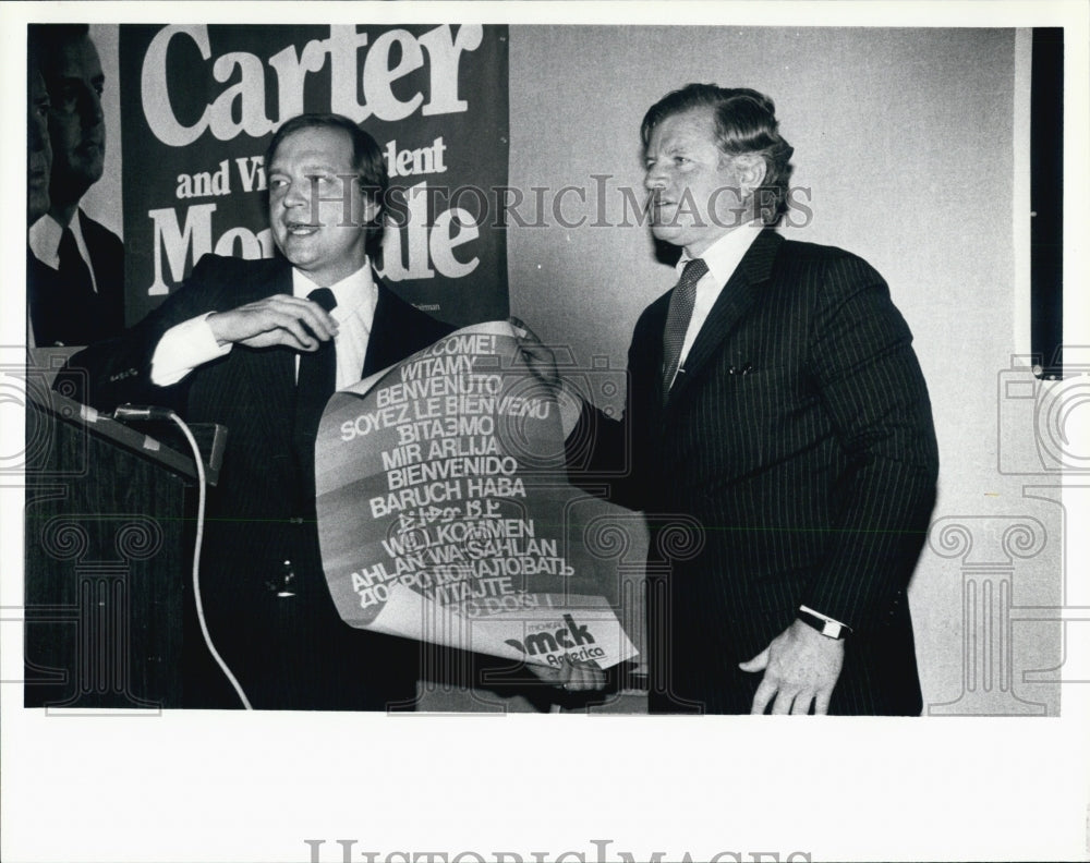 1980 Press Photo Holding a poster of 12 languages of Welcome. - Historic Images