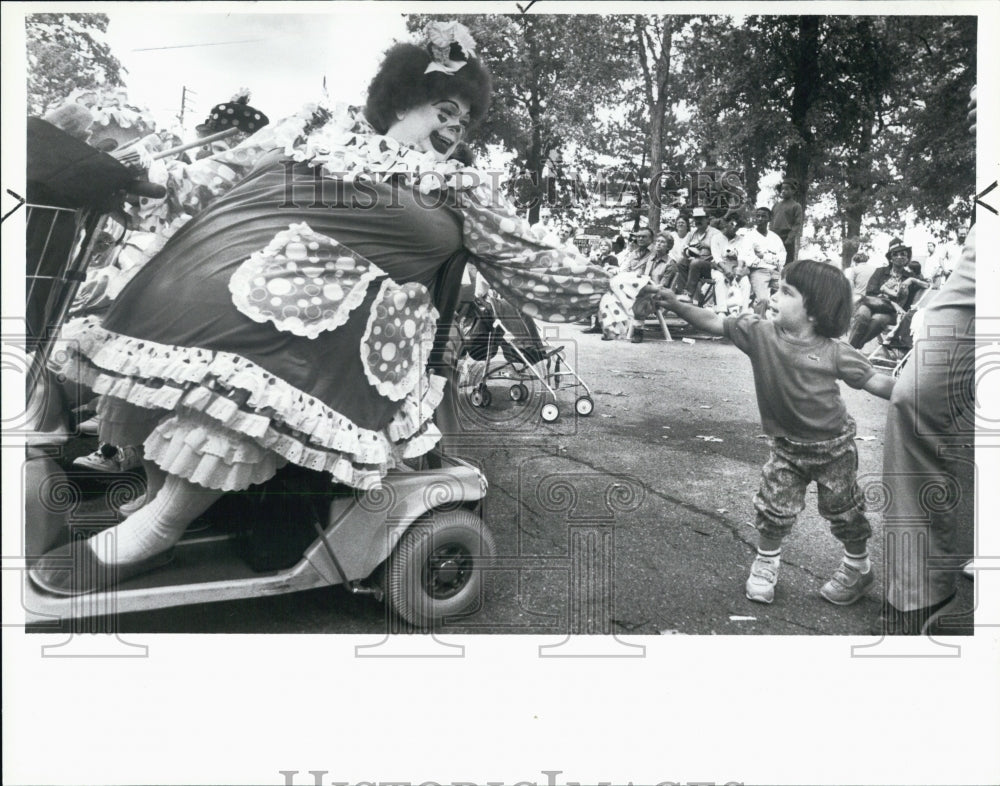 1988 Press Photo Amanda Margener,2, reaches to Buttercup Clown. State Fair, Mich - Historic Images