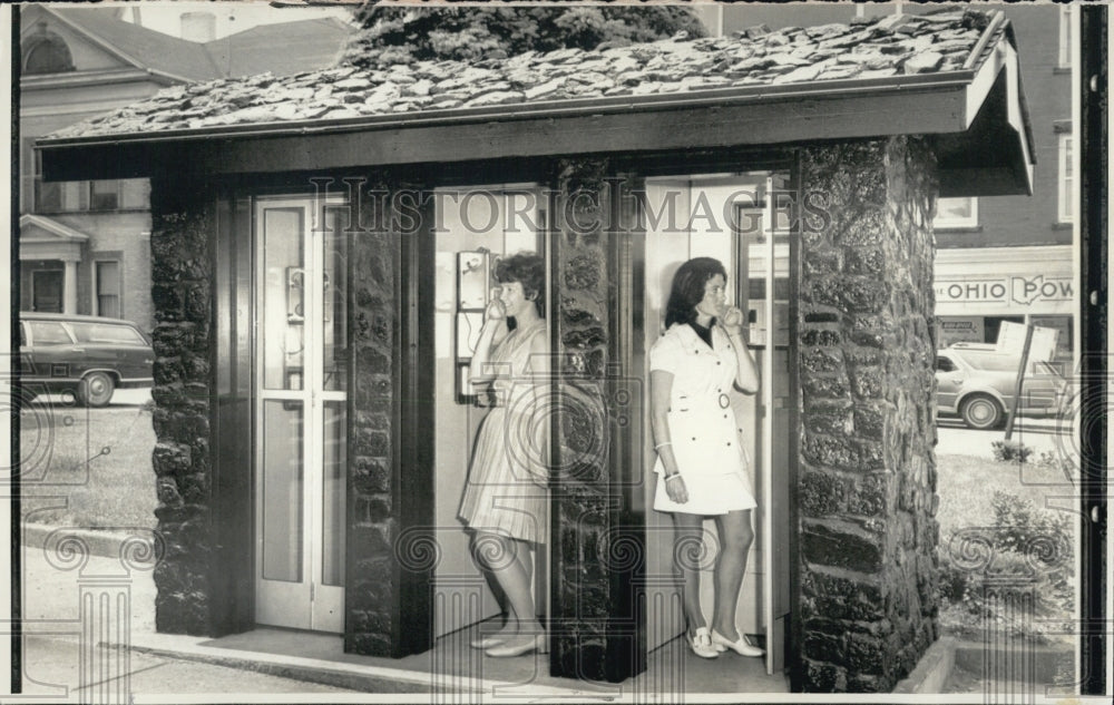 1970 Two women in phone booths - Historic Images