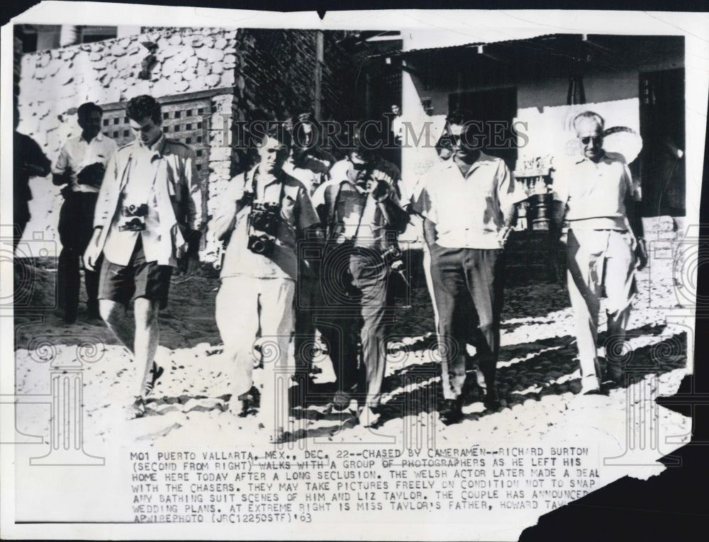 1963 Richard Burton walking with a group of photographers - Historic Images