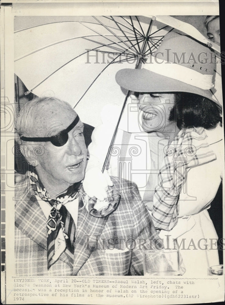 1974 Raoul Walsh chats with Gloria Swanson - Historic Images