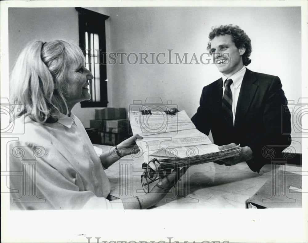 1990 Press Photo Man Hands Lady Pile Of Work Papers - Historic Images