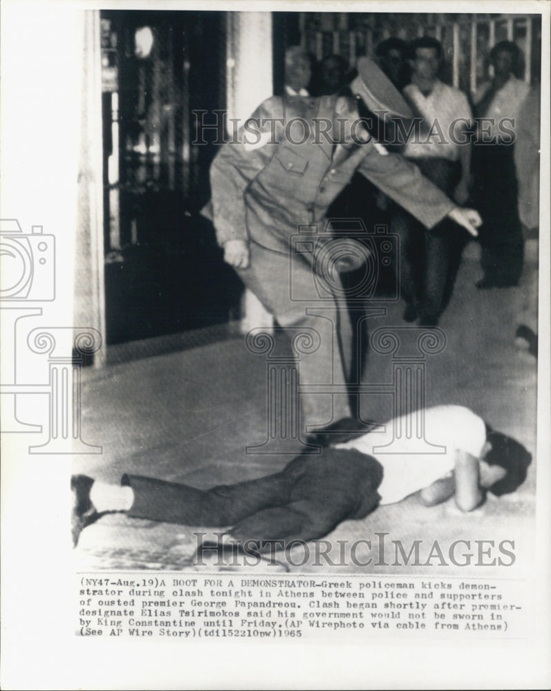 1965 Greek policeman kicking demonstrator. - Historic Images