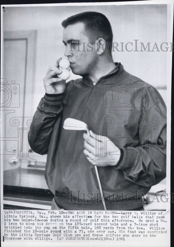 1961 Larry E springs shows his affection for the two golf balls that - Historic Images