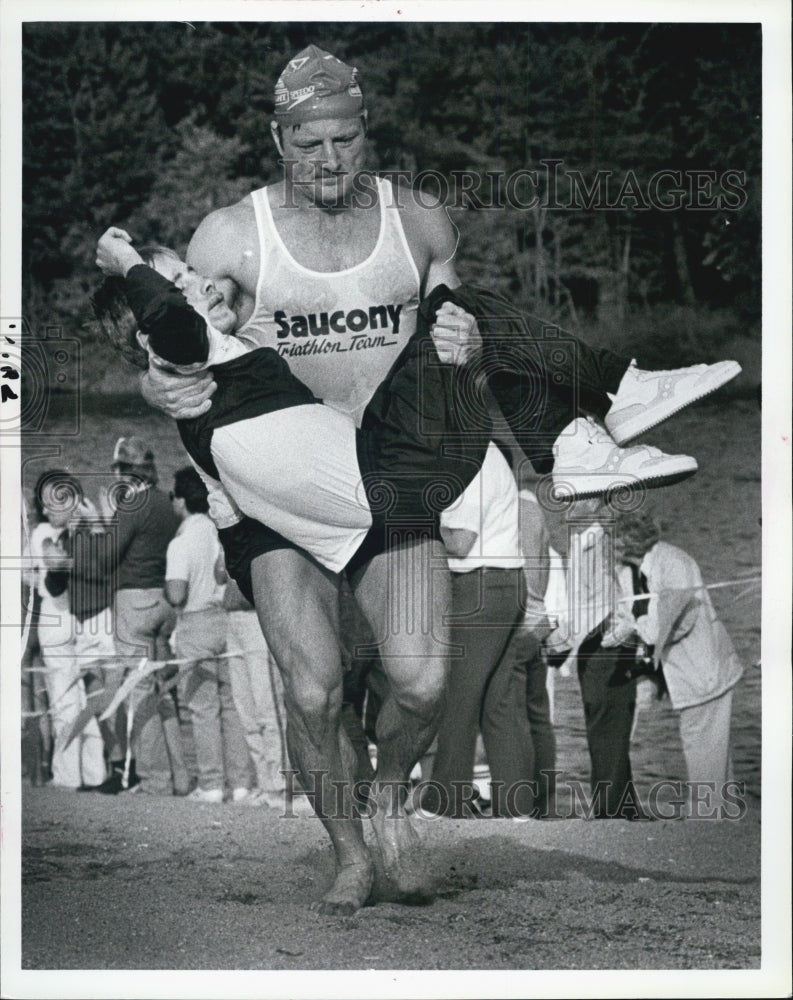 1985 Press Photo Dick Hoyt carroes Rock to bike Medford Triathlolon - Historic Images